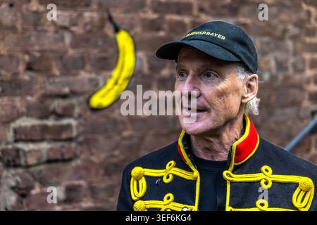 Thomas Baumgärtel at the opening of the exhibition “40 Years of Bananensprayer”. This major project runs from May to the end of September 2026 and is themed “Freedom for Art”. The NiederrheinTour 2026 will showcase 40 groups of works spanning 40 years at 40 art venues. Here, in front of the Grevenbroich dispatch hall, freshly adorned with a spray-painted banana, are images from the “Banana Pointillism” series. Grevenbroich, Nordrhein-Westfalen, Deutschland Stock Photo