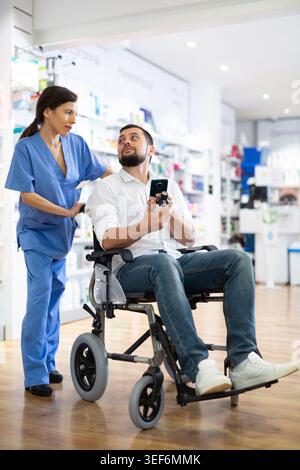Druggist helping disabled woman to choose medicine Stock Photo