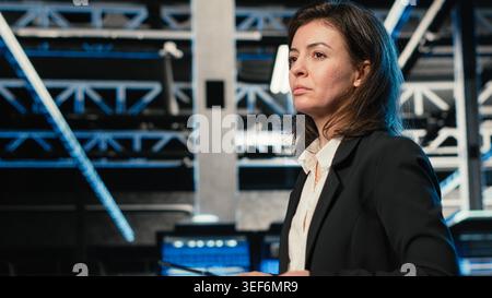 Technician walking in data center, using AR simulation to conduct security audit on IT infrastructure. Server room expert using VFX compositing visualization to verify firewall protection Stock Photo