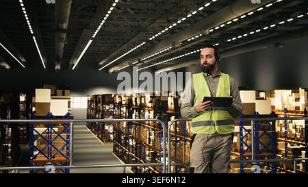 Warehouse worker, customer service calls, logistics hub, shipment details, checking parcel tracking info. Transmitting AWB numbers on headset for e-commerce operations, shipment dispatch. Stock Photo