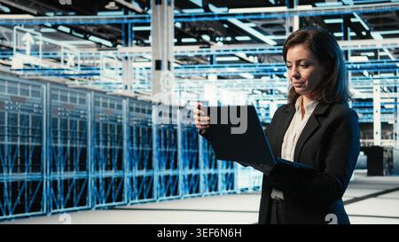 Data center system administrator using AR tech to conduct security audit on IT infrastructure. Server room employee using blue wireframe mesh visualization to verify firewall protection Stock Photo