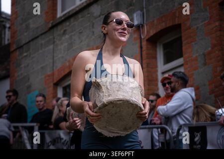 The Gold Hill Cheese Race 2026. Contestants race up the iconic steep cobbled Gold Hill carrying rounds of cheese. Shaftesbury, Dorset, UK Stock Photo