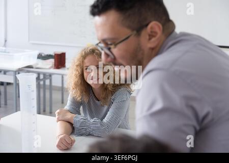 A portrait-style series showing a male instructor and female university students collaborating in a science lab. The images emphasize positive academi Stock Photo