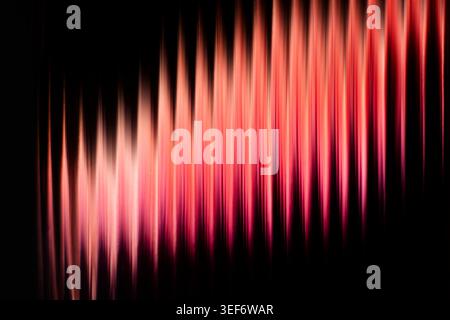Abstract vertical red and pink glowing light streaks on dark background Stock Photo