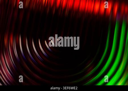 Dark abstract background with glowing green and red circular ripples Stock Photo