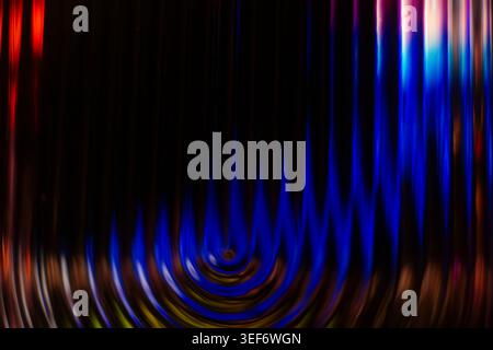 Dark abstract background with bright blue glowing concentric ripples at the base Stock Photo