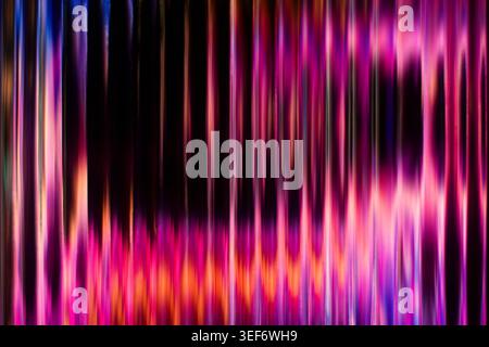 Abstract glowing pink and purple vertical lines on a dark background resembling ribbed glass Stock Photo