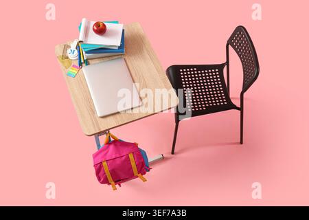 Modern school desk with backpack, laptop and stationery on pink background Stock Photo