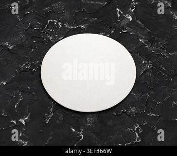 Blank white round beer coaster mockup on black textured surface. Responsive design mockup Stock Photo