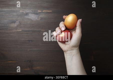 Easter eggs in female hand on wooden background Stock Photo