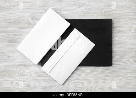 Blank white envelopes on stone board. Copy space. Flat lay Stock Photo