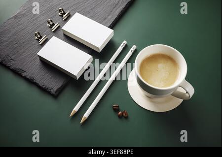 Blank stationery and coffee cup on green background Stock Photo