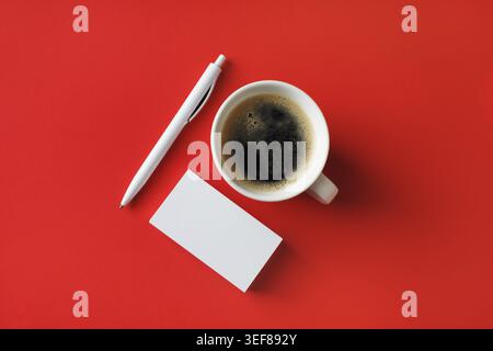 Branding ID template. Blank business cards, coffee cup and pen on red paper background. Flat lay Stock Photo
