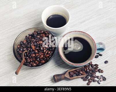Photo of fresh tasty coffee on light wood table background. Coffee cups and coffee beans Stock Photo