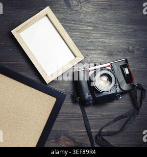 Vintage camera and blank photo frames on wood table background. Flat lay Stock Photo