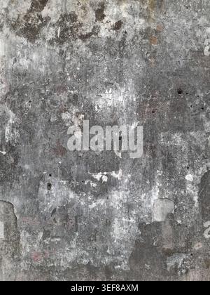 Close-up of an aged concrete wall with rough grain, peeling white residue, and dark mildew speckles, creating a gritty monochrome grunge texture perfe Stock Photo