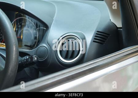 Close up detail of modern car interior showing clean plastic dashboard with an air conditioning vent in functional vehicle providing auto climate cont Stock Photo