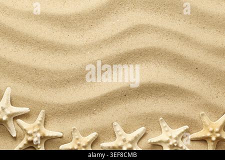 Starfishes on wavy sand background for summer designs. Top view, flat lay Stock Photo