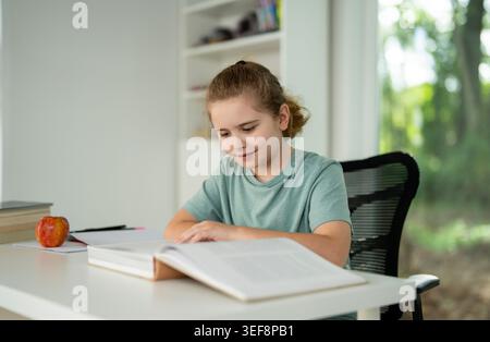 Kid reading book at home. Kid book studying. Child opening book indoors. Kid earning with books. Boy focused on textbook lesson. Clever teen reading Stock Photo
