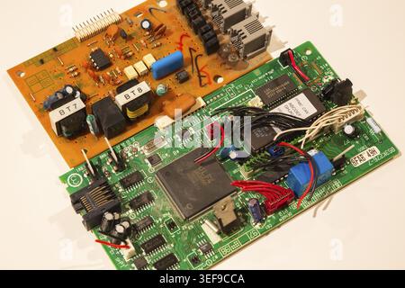 Close-up of printed circuit board with integrated circuits, electronic components and electrical wires inside modem router devices on white background Stock Photo
