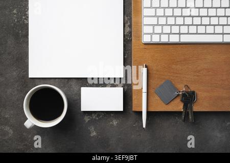 Real estate concept. Blank business card, coffee cup, key, keyboard, pen and paper. Flat lay Stock Photo