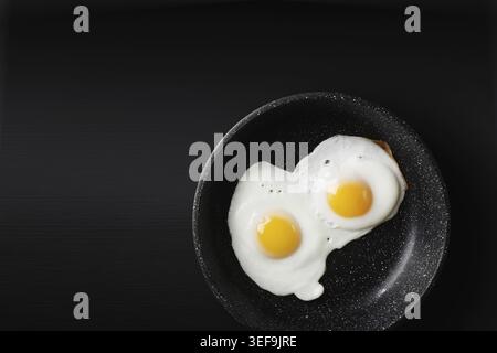 Fried eggs in skillet. Copy space for your text. Flat lay Stock Photo