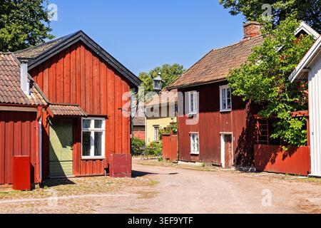Old red wooden houses on a cobblestone street in a old town Stock Photo