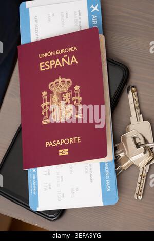 Spain passport, flight boarding pass, smartphone, and keys displaying international travel Stock Photo