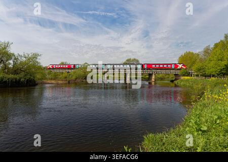 Refurbished, new red coloured Arriva Cross Country class 220 Voyager train crossing the River Tame Wychnor viaduct Alrewas heading towards Birmingham Stock Photo