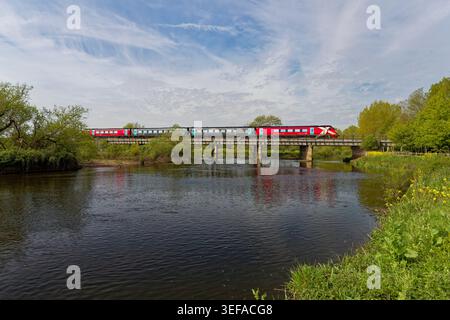 Refurbished, new red coloured Arriva Cross Country class 220 Voyager train crossing the River Tame Wychnor viaduct Alrewas heading towards Birmingham Stock Photo