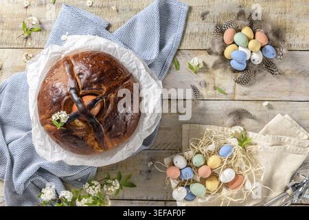 Portuguese traditional Easter cake. Folar with eggs on easter table. Colorful painted eggs Stock Photo