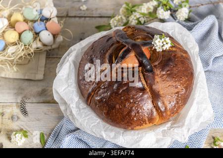 Portuguese traditional Easter cake. Folar with eggs on easter table. Colorful painted eggs Stock Photo