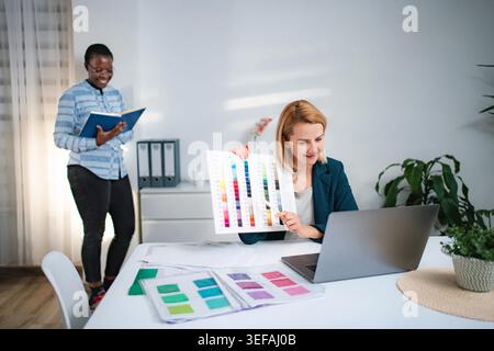 Diverse female designers collaborating on creative project using color swatches Stock Photo