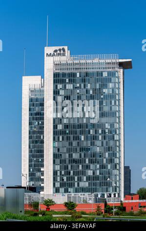 Milan, Lombardy, Italy - April 22, 2026: Modern MAIRE headquarters building with glass facade and logo against a clear blue sky Stock Photo