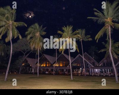 Bright full moon shines over the Anjajavay Resort by palm trees in Madagascar at night Stock Photo