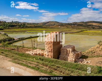 Bricks stacked along the road in Madagascar near rice fields during the day Stock Photo