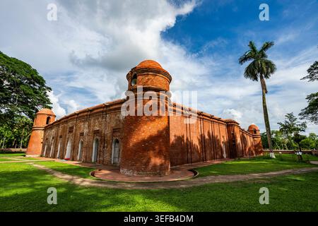Sixty Dome Mosque features unique architecture with red brick walls and large dome structures in Bangladesh Stock Photo