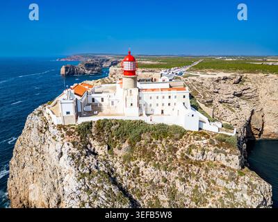 View from above of Cabo de Sao Vicente lighthouse on a cliff near the ocean in Sagres, Algarve, Portugal showcasing coastal landscape Stock Photo