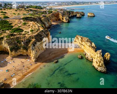 Beach cliffs at sunset with water and sand in Algarve during the evening Stock Photo
