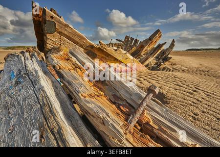 Disintegrating wreck rests on the beach at Crow Point in Devon near Barnstaple under a cloudy sky Stock Photo
