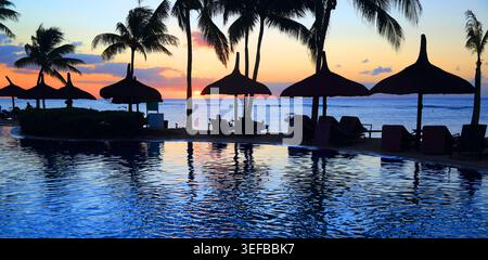 Sunset view from resort pool overlooking ocean at Pointe aux Piments Mauritius Stock Photo