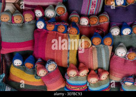 Colorful textiles and handcrafted dolls displayed at traditional center in Chinchero, Peru creating a vibrant cultural showcase Stock Photo