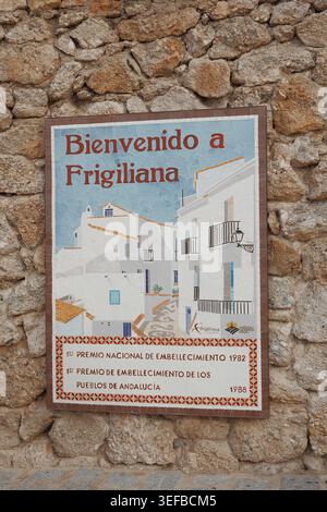 Mosaic tile welcome sign "Bienvenido a Frigiliana" on a stone wall, featuring national beautification award inscriptions from 1982 and 1988, Andalusia Stock Photo
