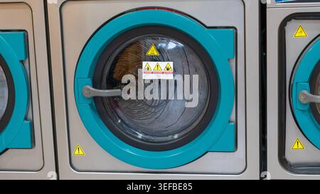 Industrial washing machine door close up in laundromat Stock Photo