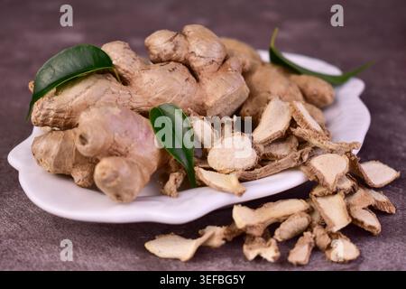 Ginger root and sliced on old plank with nature background. Close-up, Selective focus Stock Photo