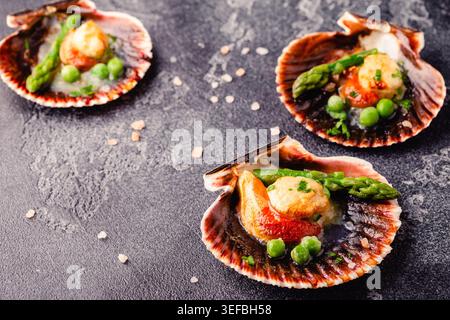 Cooked scallops with vegetables on a dark background Stock Photo