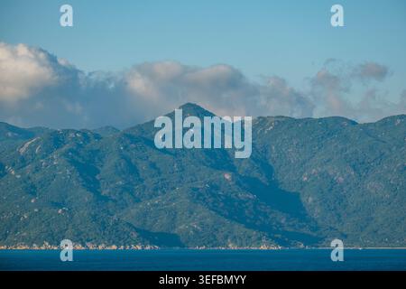 Lush Green Coastal Mountain Range Under Billowing Clouds in Vietnam Stock Photo