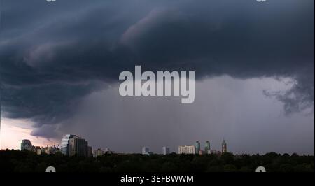 Aerial view of dramatic storm clouds and heavy rain over the city skyline and lush green trees Toronto, Ontario, Canada. Stock Photo
