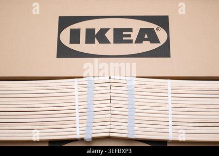 Prague, CZ -21.05.2023: wooden slats and a steel rail rest on IKEA branded cardboard packaging during home assembly. The flat pack components represen Stock Photo