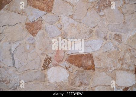textured wall surface displays variations in color and material. The rough finish creates a distinct visual pattern Stock Photo